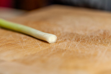 Fototapeta na wymiar Single scallion on a chopping board