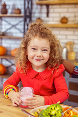 Positive delighted little female posing on camera