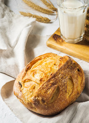 Homebaked bread. Loaf of white bread with milk in the morning table