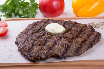 Prepared steak served with butter on board
