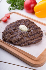 Prepared steak served with butter on board