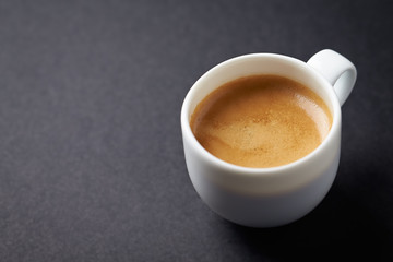 Cup of coffee on black background. Copy space.