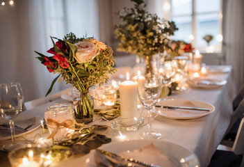 Table set for a meal indoors in a room on a party, a wedding or family celebration.