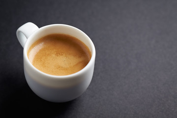 Cup of coffee on black background. Copy space.