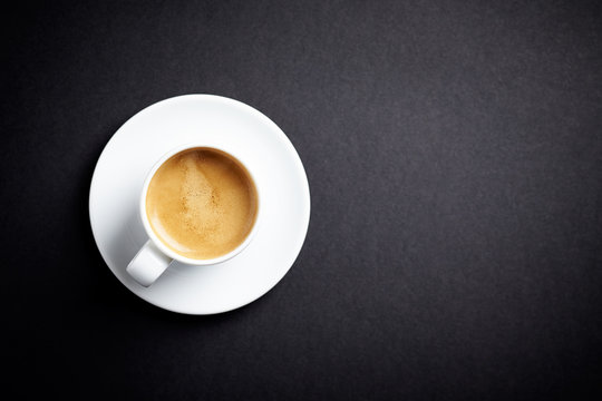 Cup of coffee on black background. Top view. Copy space.