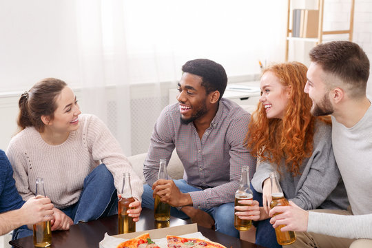 Friends having little party, eating pizza at home
