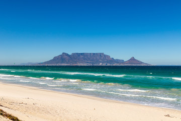 Surf und Kite Strand in Kapstadt vor dem Tafelberg, türkieses Wasser