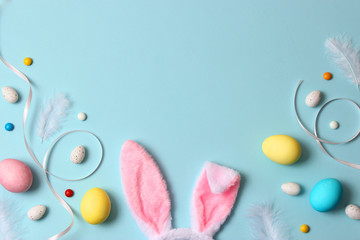  Easter composition of painted eggs and feathers on a colored background. Easter background