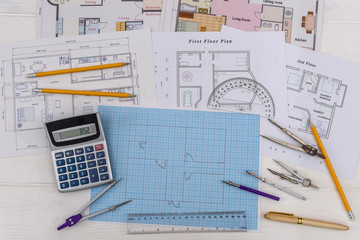 Architectural sketch of house on millimeter paper with tools