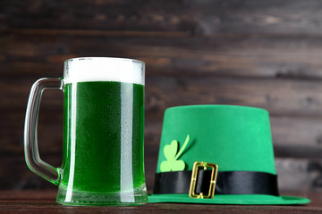 St. Patrick's Day. Green beer in mug with hat on wooden background