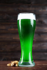 St. Patrick's Day. Glass of green beer with wheat ears on wooden background