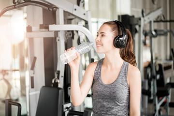 Pretty young sport woman is drinking water  in gym, Healthy lifestyle