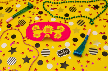 Top view decoration for party. Pink eye mask, plastic necklaces, party blowers and circles and...