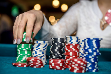 Naklejka premium Female hands with piles of poker chips closeup