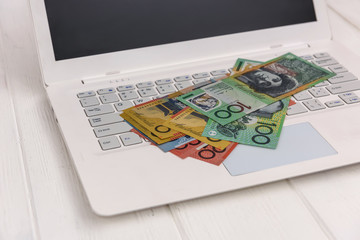 Fototapeta na wymiar Australian dollar banknotes on white laptop keyboard
