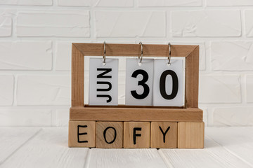 Wooden calendar with cubes and word EOFY