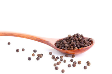 Black pepper in a spoon on a white background.