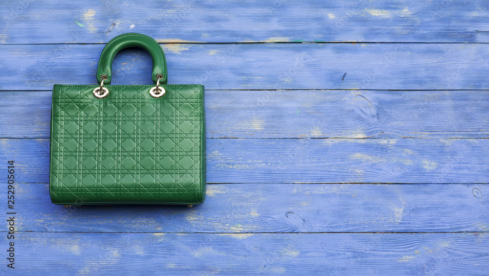 Wall mural green handbag on blue wooden