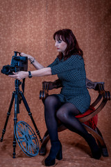 Fototapeta na wymiar beautiful woman sitting in a photo studio playing with a camera