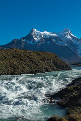 Waterfall cascading with a thunderous roar with a mountain range in the background, Torres del Paine, National Park, Chile