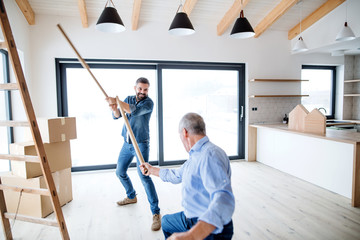 Two men having fun when furnishing new house, a new home concept.