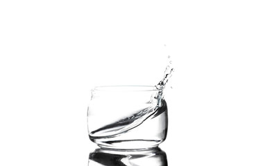 Splash of water in a glass cup on a white background