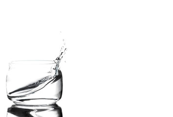 Fototapeta na wymiar Splash of water in a glass cup on a white background