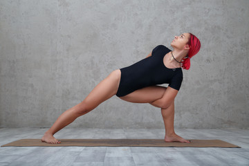 A girl with pink hair practices yoga.