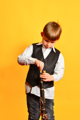 A little boy in costume tunes the clarinet before playing the music scene