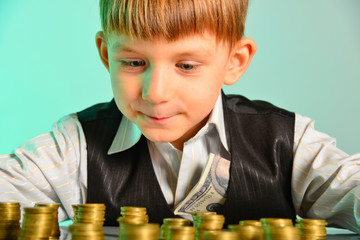 The little boy looks at his cash savings with pleasure. The greedy and vicious concept of the...