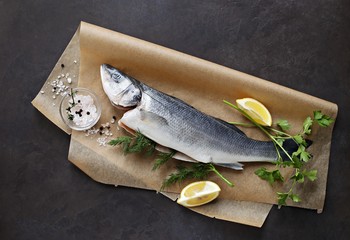 Raw fish with vegetables, herbs and spices. Sea bass. Overhead view