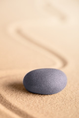 Fototapeta na wymiar zen meditation stone in a Japanese garden with raked sand. Rock for focus and concentration for balance and spirituality.