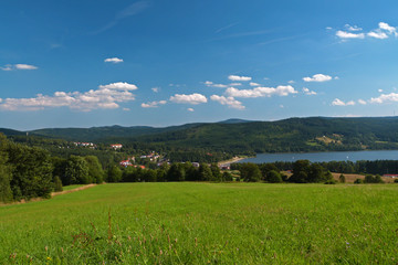 Fototapeta premium Panorama view of Lipno Lake with blue sky and green meadow, Czech Repubilc
