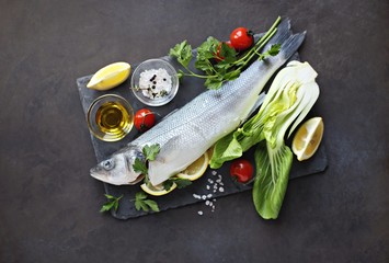 Raw fish with vegetables, herbs and spices. Sea bass. Overhead view
