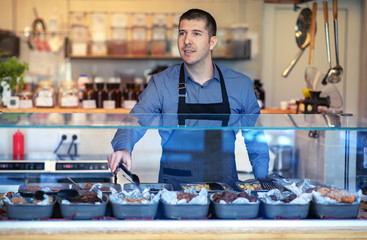 Man wearing apron in bistro - Employee in fast-food serving food - Small Business Concept