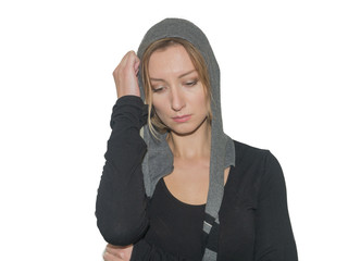 A young blond woman in a gray sweatshirt has put on a hood on her head,  looking down.  isolated on a white background