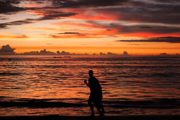 Background sky sunset,Silhouette Jogging on the beach,Bright in Phuket Thailand.