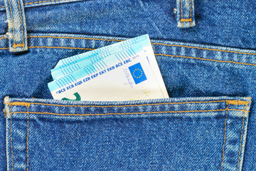 Several bills of twenty euros in the back pocket of jeans. Concept of absentminded person, potential victim of theft.