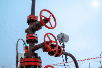 close-up of the valve plug an oil pipeline in the field on a sunny  day. Oil valve with rocking in...