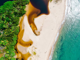 Aerial top of river tropical merging to white sand beach and turquoise clear sea water with small...