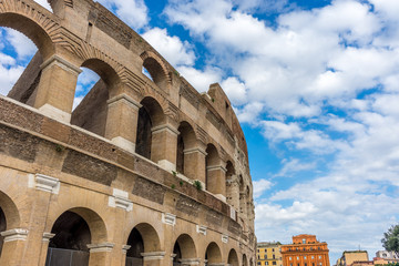 Obraz premium Facade of the Great Roman Colosseum (Coliseum, Colosseo), also known as the Flavian Amphitheatre. Famous world landmark. Scenic urban landscape.