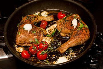 Roasted chicken legs with white cheese and tomatoes