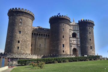 Fototapeta na wymiar Old stone Maschio Angioino castle in a modern European city. Fort in Naples. Sunny day with blue sky