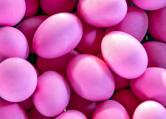 Lots of pink eggs. Prepared and painted for Easter. Pink background, texture.