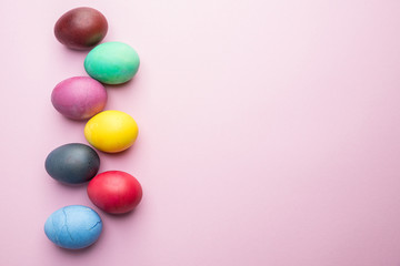 Colorful Easter eggs as an attribute of Easter celebration. Pink background.