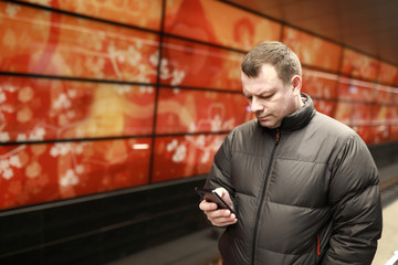 Person with smartphone waiting train