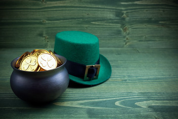 Happy St Patricks Day leprechaun hat with gold coins on vintage style green wood