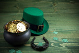 Happy St Patricks Day leprechaun hat with gold coins and lucky charms on vintage style green wood