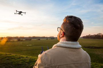 male drone pilot flying a drone responsibly by following the drone code with remote control