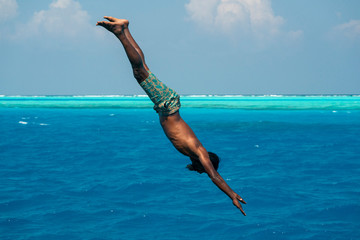maldivian man diving from boat